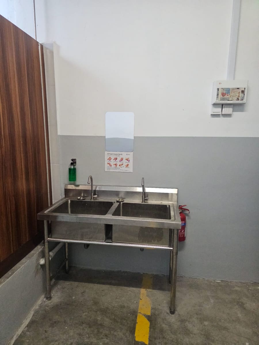 Communal wash basins with hygiene guide — NextDorm31@Tuas dormitory in Tuas, Singapore